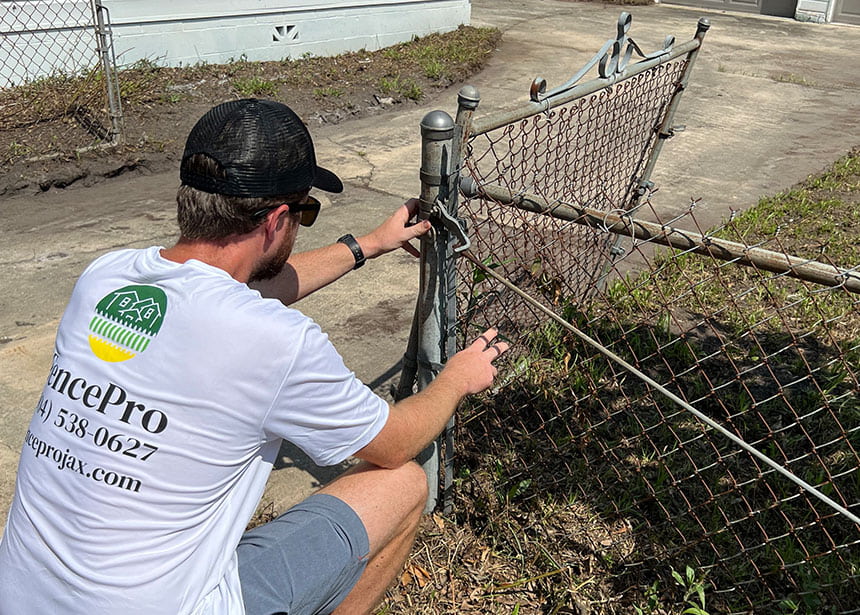 Fencepro Technician Making A Repair In Jacksonville