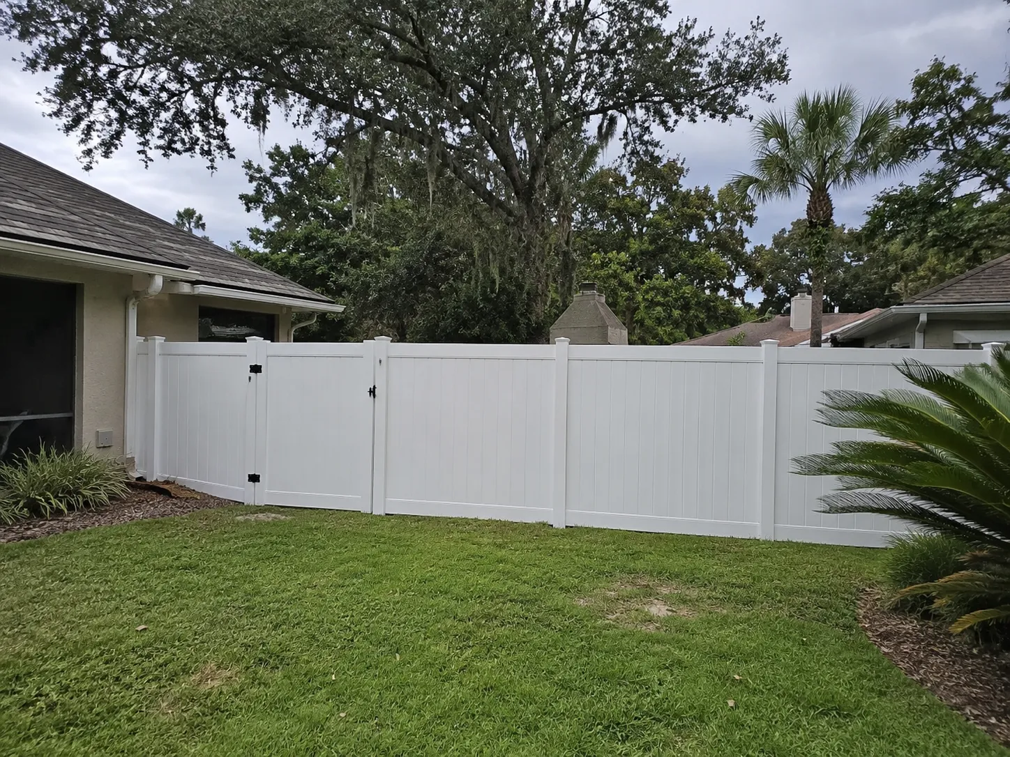 White vinyl privacy fence installed around a Jacksonville FL backyard