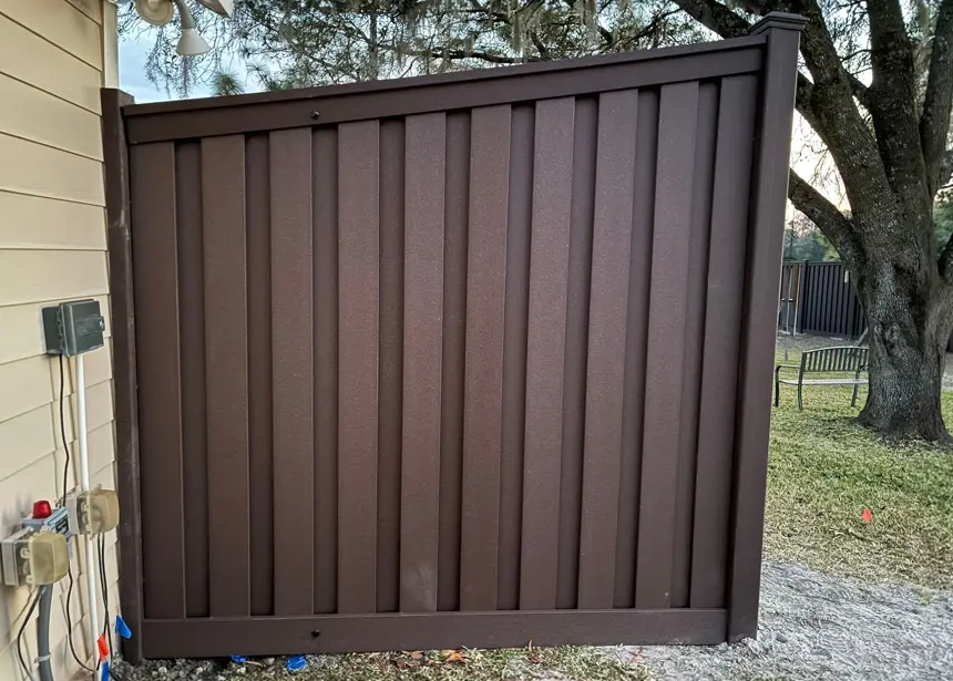 Composite Trex fence installation with wood-look finish