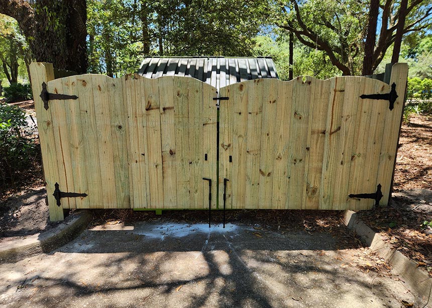 Wooden Double Gate In Front Of Trash